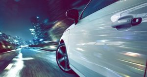 ぼかしスタイルで道路を運転中の白い車