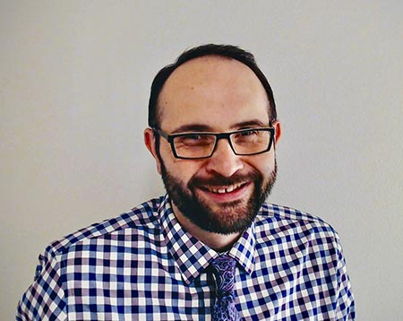 Middle-aged caucasian male in a checkered blue button up shirt and blue tie