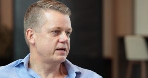 Middle-aged Caucasian male wearing a business casual blue shirt