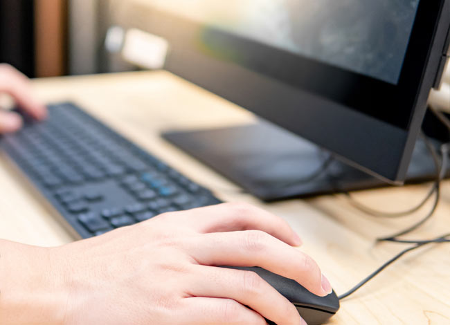 Computer with focus on hand over mouse and keyboard